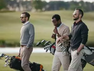 3 Golfers carrying golf bags